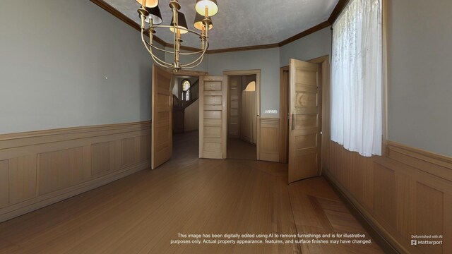 36 Cutler Rd, East Machias, ME 04630 - unfurnished dining area featuring a wainscoted wall, crown molding, a chandelier, and light wood finished floors