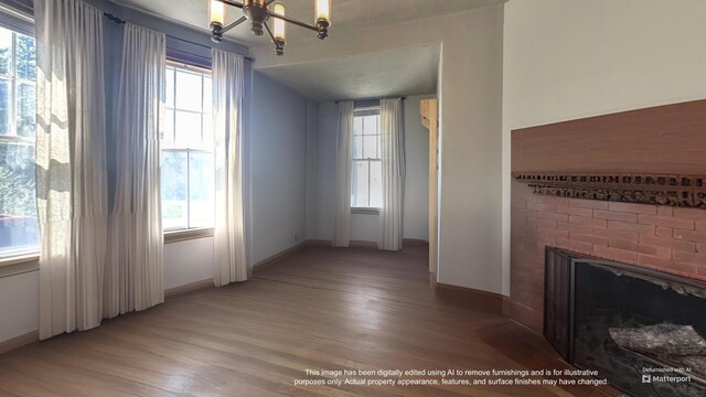 36 Cutler Rd, East Machias, ME 04630 - unfurnished living room featuring a chandelier, light wood-style floors, baseboards, and a fireplace