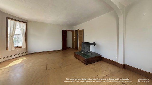 36 Cutler Rd, East Machias, ME 04630 - unfurnished living room with a baseboard heating unit, wood finished floors, a wood stove, and baseboards