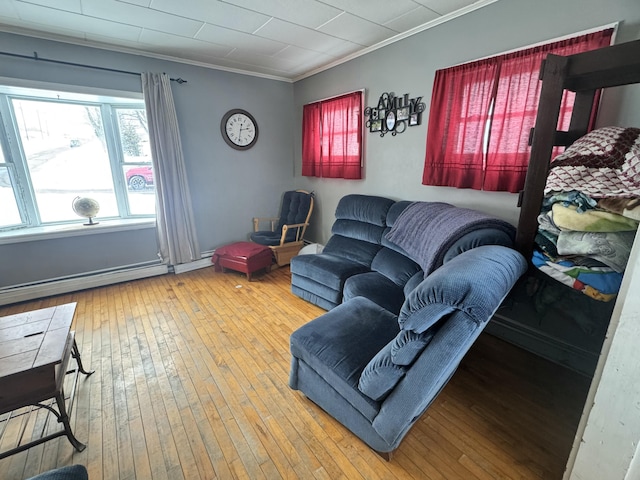 living room with hardwood / wood-style flooring, a baseboard radiator, and ornamental molding