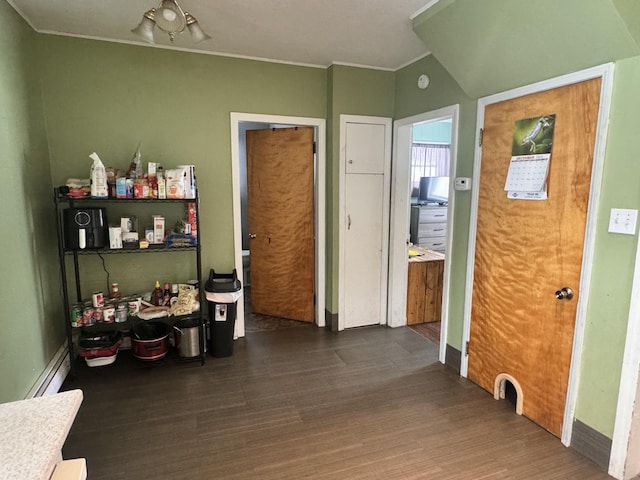 interior space with wood finished floors, baseboard heating, and ornamental molding