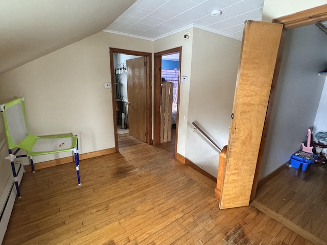 bonus room with hardwood / wood-style floors, baseboards, and a baseboard heating unit