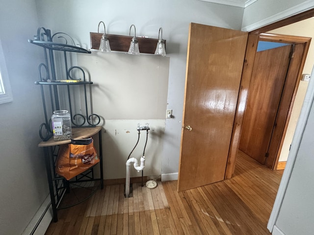 washroom with wood-type flooring, baseboards, and a baseboard radiator