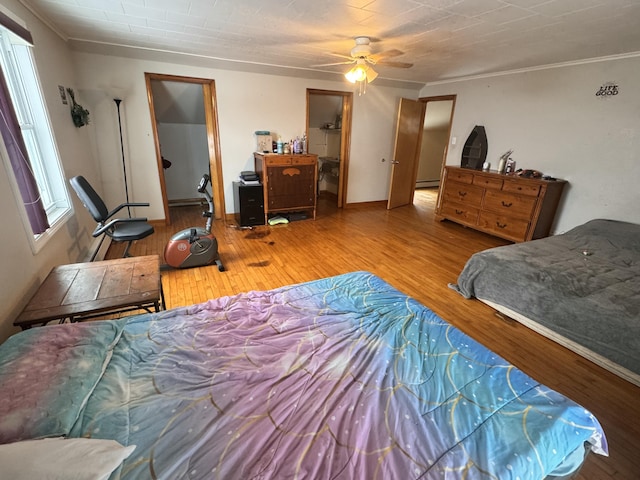 bedroom featuring hardwood / wood-style flooring, ceiling fan, and crown molding