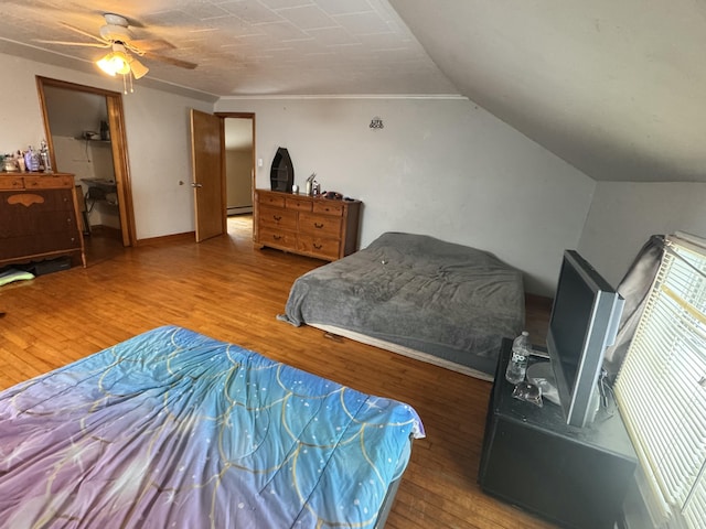 bedroom featuring baseboards, wood finished floors, ceiling fan, and crown molding