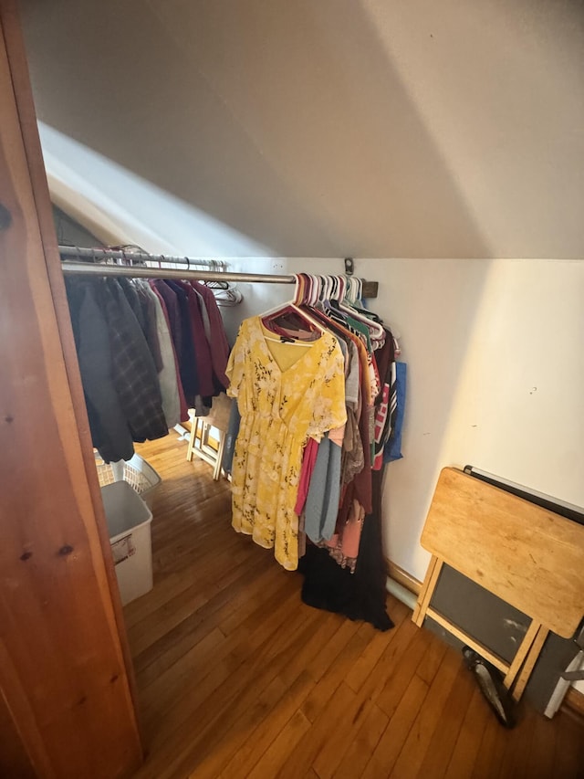 spacious closet featuring hardwood / wood-style floors and vaulted ceiling