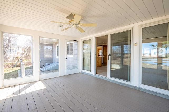 unfurnished sunroom with ceiling fan