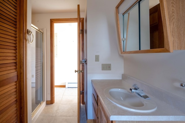 bathroom with a baseboard radiator, a shower stall, tile patterned floors, and vanity