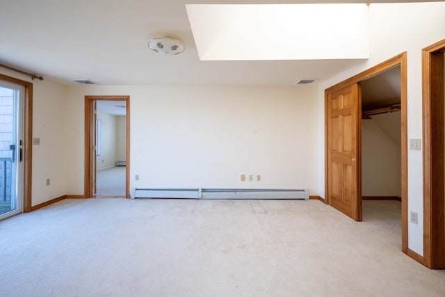 unfurnished bedroom with a baseboard heating unit, light carpet, and visible vents