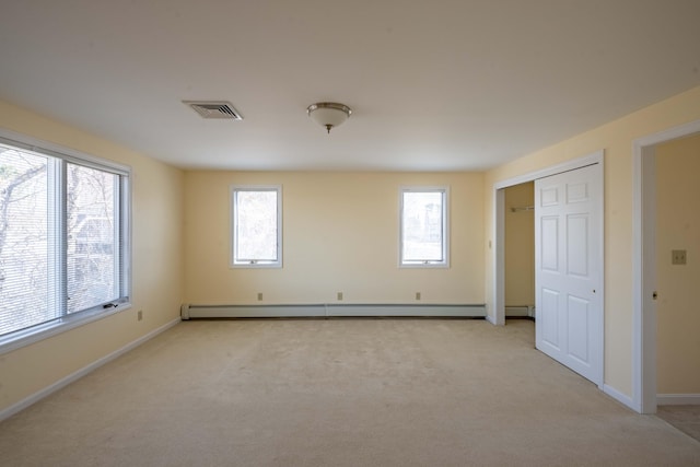 unfurnished bedroom with visible vents, a closet, baseboards, a baseboard radiator, and light colored carpet