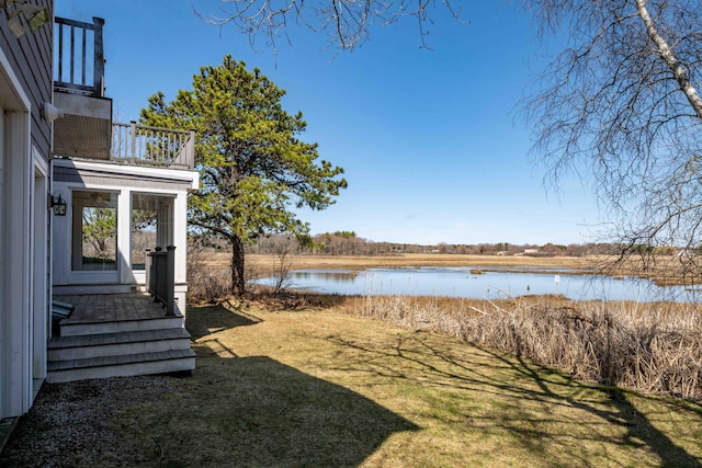 view of yard featuring a balcony and a water view