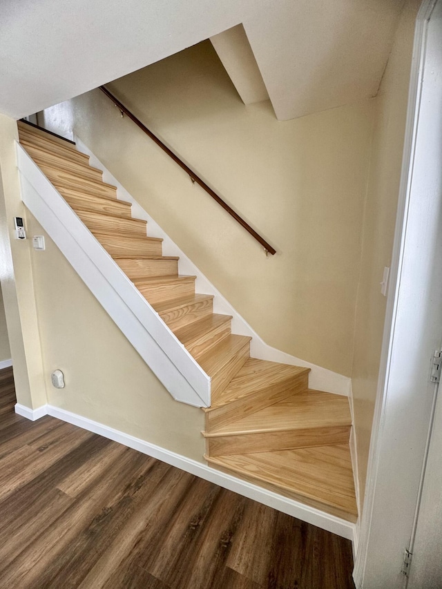staircase with wood finished floors and baseboards