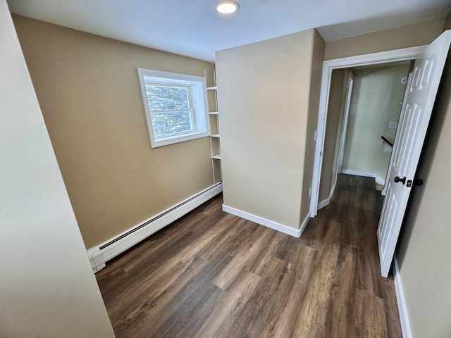 spare room with a baseboard heating unit, wood finished floors, baseboards, and recessed lighting