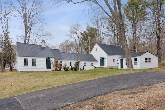 37 Main St, Raymond, ME 04071 - view of front of home featuring a chimney, a front lawn, metal roof, and aphalt driveway