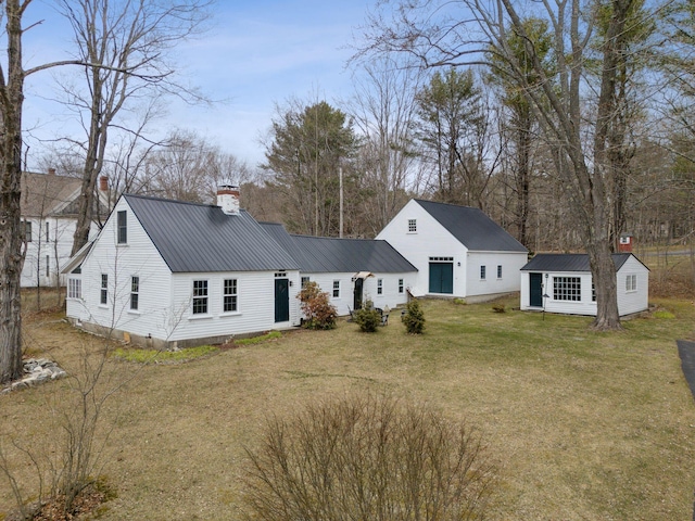 37 Main St, Raymond, ME 04071 - rear view of property featuring a lawn, an outbuilding, a chimney, and metal roof