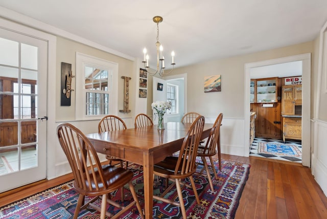 37 Main St, Raymond, ME 04071 - dining space featuring plenty of natural light, wood-type flooring, a wainscoted wall, and a notable chandelier