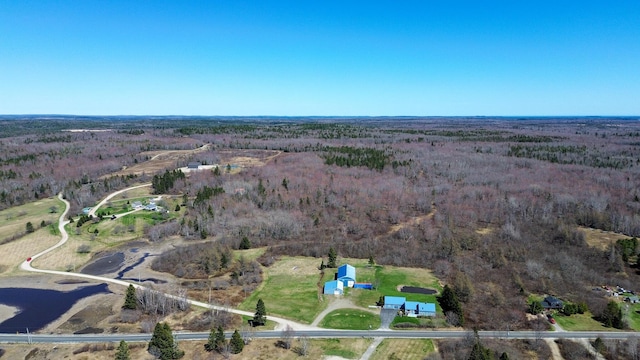 aerial view of property and surrounding area featuring a heavily wooded area