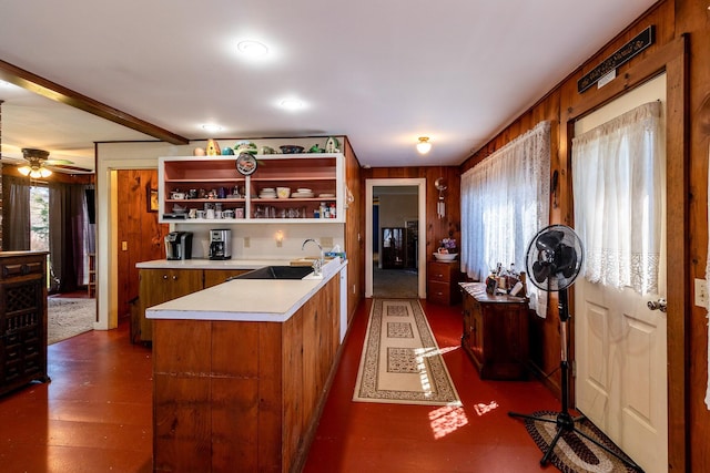 kitchen with a sink, open shelves, light countertops, ceiling fan, and a peninsula
