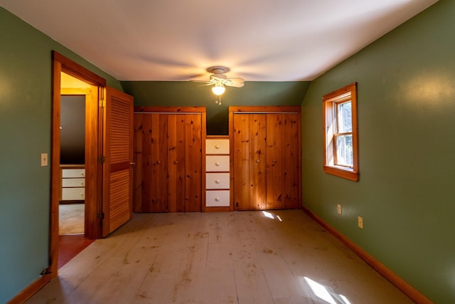 unfurnished bedroom featuring wood finished floors, vaulted ceiling, baseboards, and a ceiling fan