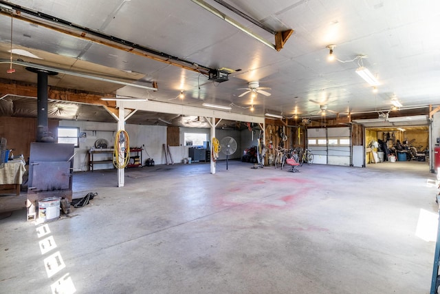 garage featuring a ceiling fan and a wood stove