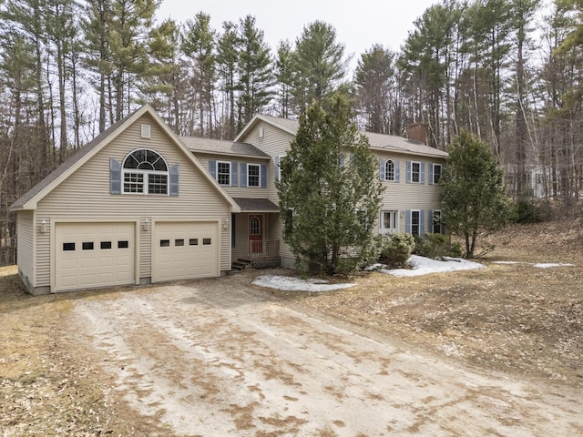 view of front facade with dirt driveway and a garage