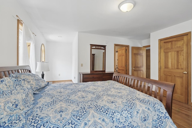 bedroom featuring baseboards and wood finished floors
