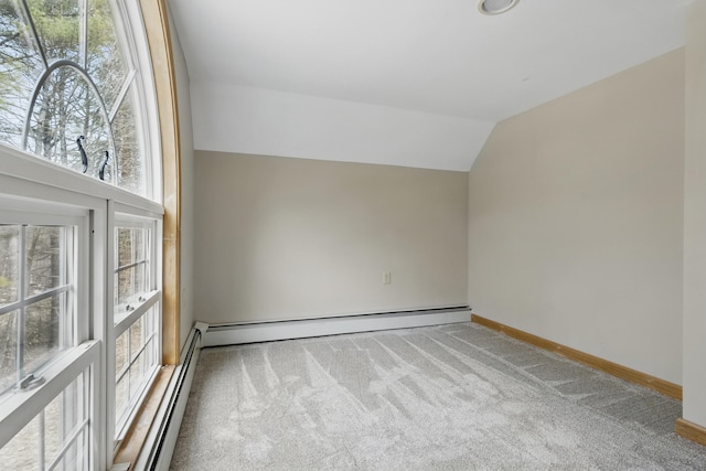 spare room with lofted ceiling, baseboard heating, baseboards, and carpet floors