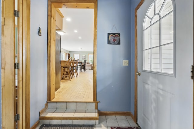 doorway featuring baseboards, tile patterned flooring, and recessed lighting