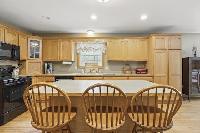kitchen with light wood-style flooring, light countertops, a sink, light brown cabinets, and black appliances