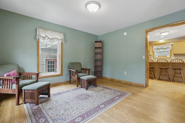 sitting room with baseboards and light wood-style floors