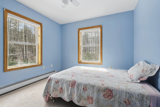 bedroom with a baseboard heating unit, a ceiling fan, and carpet flooring