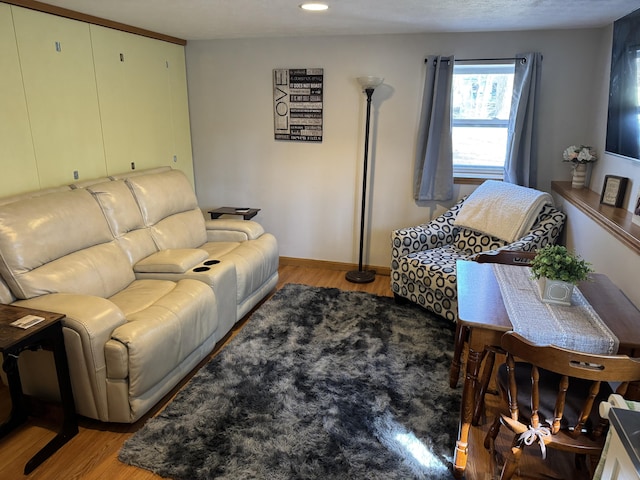 living room featuring recessed lighting, baseboards, and light wood-style flooring