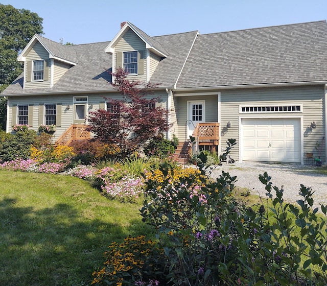 cape cod-style house with an attached garage, gravel driveway, stairs, a shingled roof, and a front yard