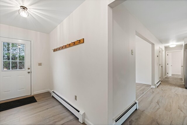foyer with light wood-type flooring, baseboards, and a baseboard heating unit