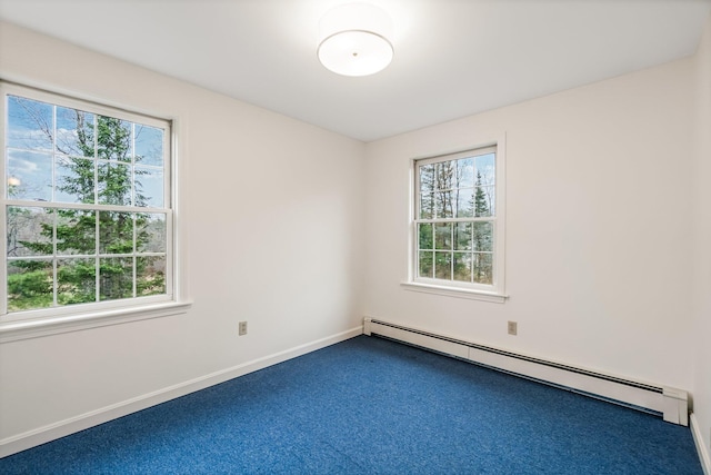 carpeted empty room with a wealth of natural light, baseboards, and a baseboard heating unit