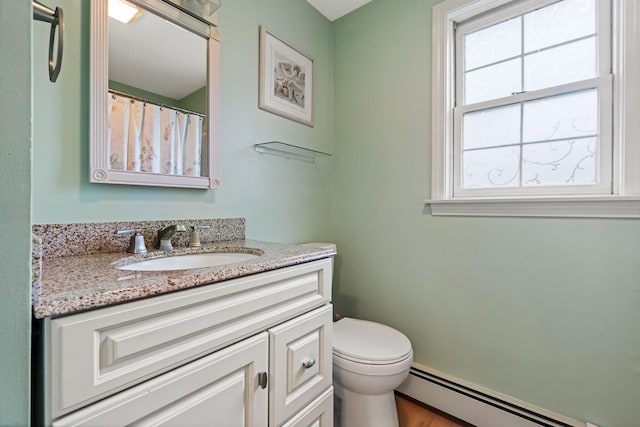 bathroom featuring vanity, toilet, wood finished floors, and a baseboard radiator