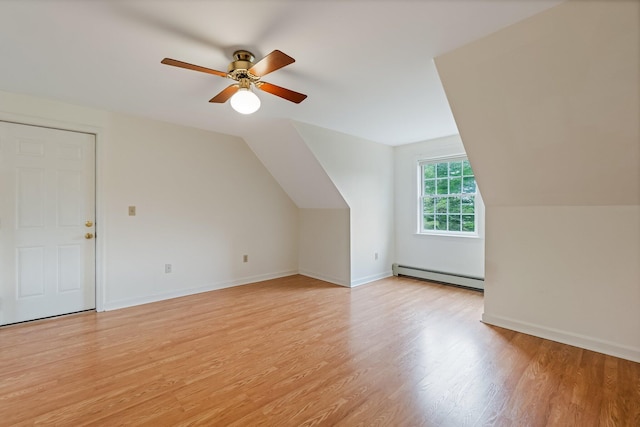 bonus room with lofted ceiling, baseboard heating, baseboards, ceiling fan, and light wood-style floors