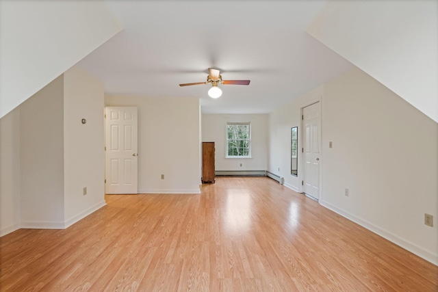 additional living space featuring a baseboard radiator, light wood-type flooring, baseboards, and a ceiling fan