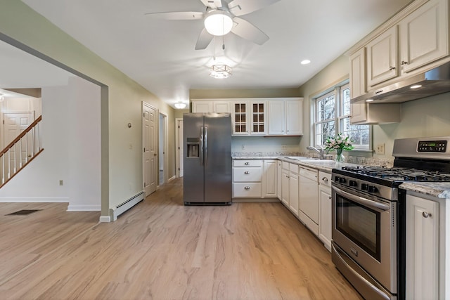 kitchen featuring a sink, stainless steel appliances, light wood-type flooring, under cabinet range hood, and baseboard heating