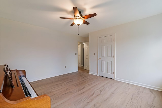 empty room featuring a ceiling fan, baseboards, and wood finished floors