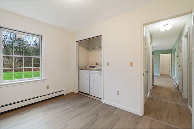 laundry area featuring separate washer and dryer, plenty of natural light, light wood-style flooring, and a baseboard radiator