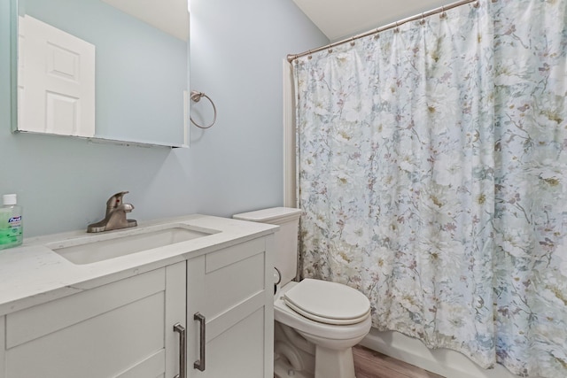bathroom with shower / bath combo with shower curtain, toilet, wood finished floors, and vanity