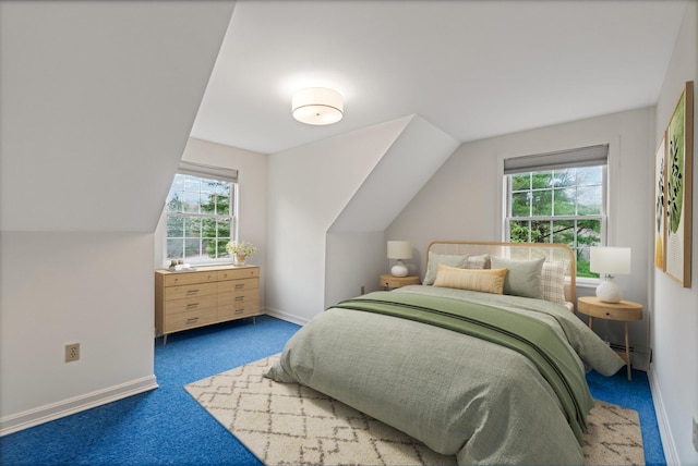 carpeted bedroom with baseboards, multiple windows, a baseboard radiator, and vaulted ceiling
