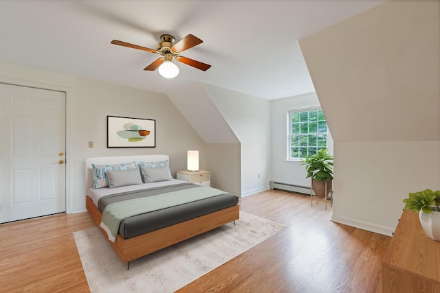 bedroom featuring light wood finished floors, a ceiling fan, lofted ceiling, and baseboard heating