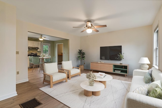living room with visible vents, a ceiling fan, and a healthy amount of sunlight
