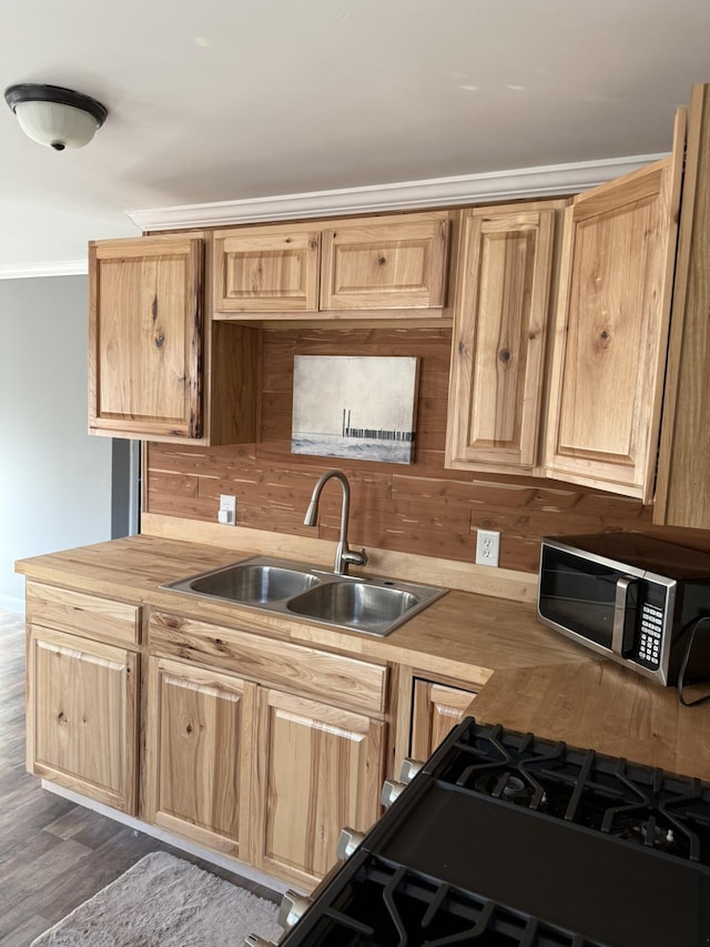 kitchen featuring a sink, stainless steel microwave, dark wood finished floors, gas stove, and light brown cabinets