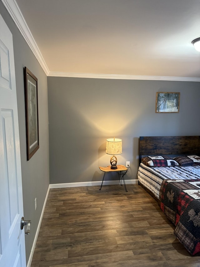 bedroom featuring wood finished floors, crown molding, and baseboards