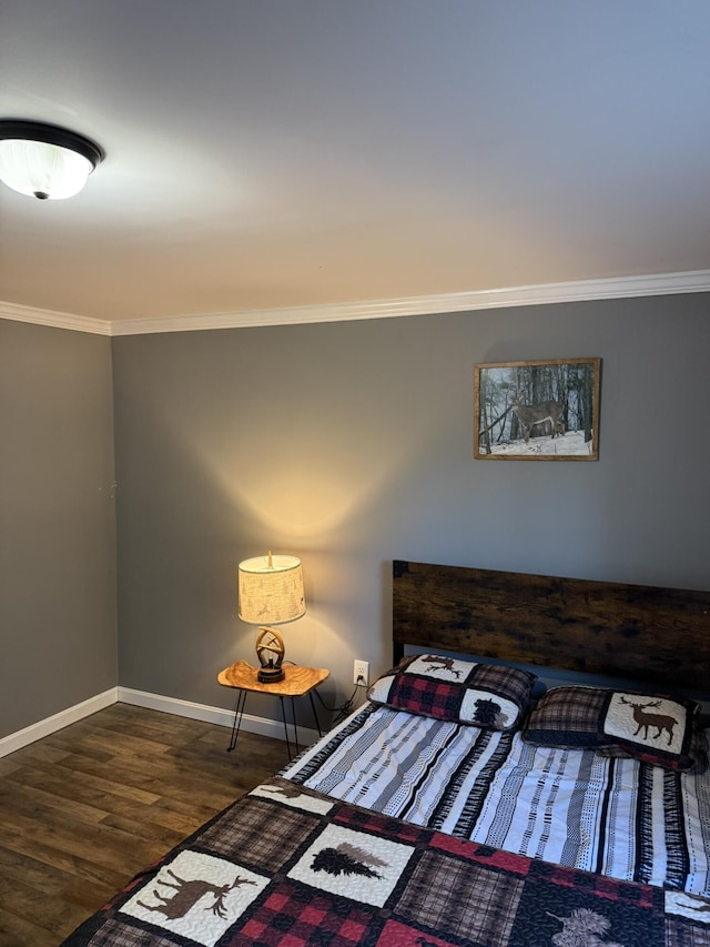 bedroom with baseboards, crown molding, and wood finished floors