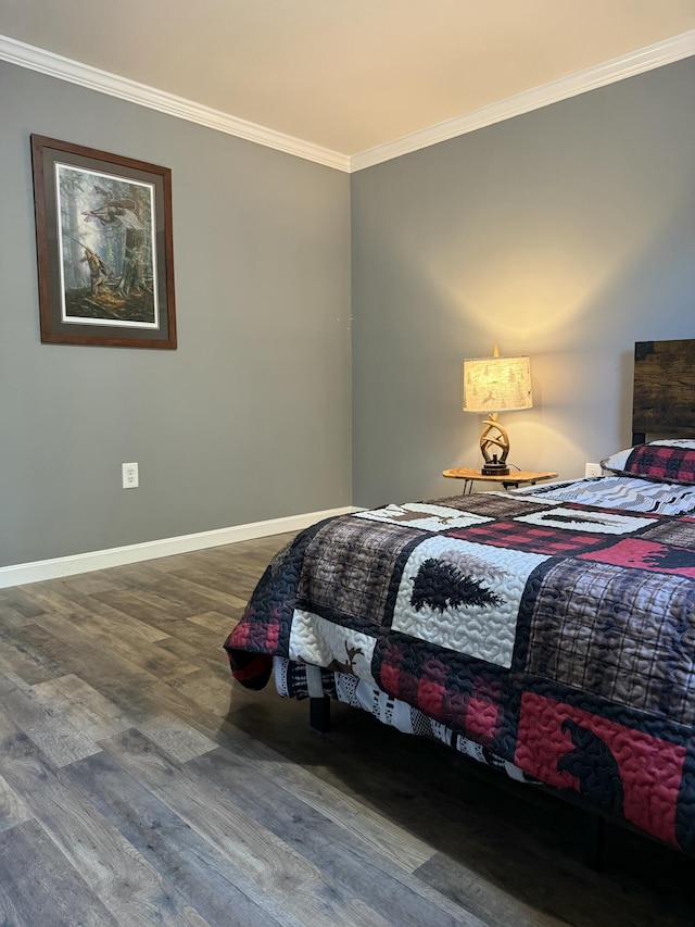bedroom with baseboards, ornamental molding, and wood finished floors