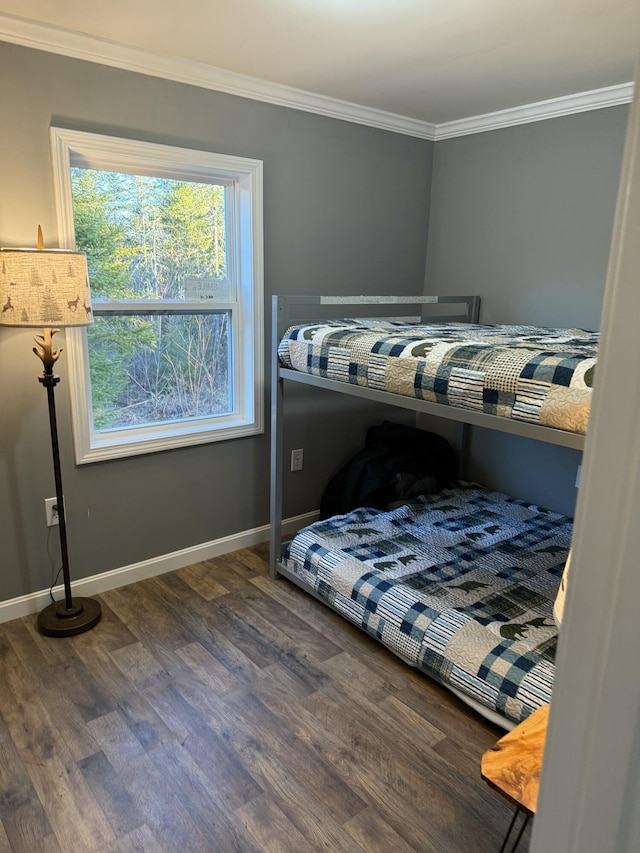bedroom featuring baseboards, ornamental molding, and wood finished floors